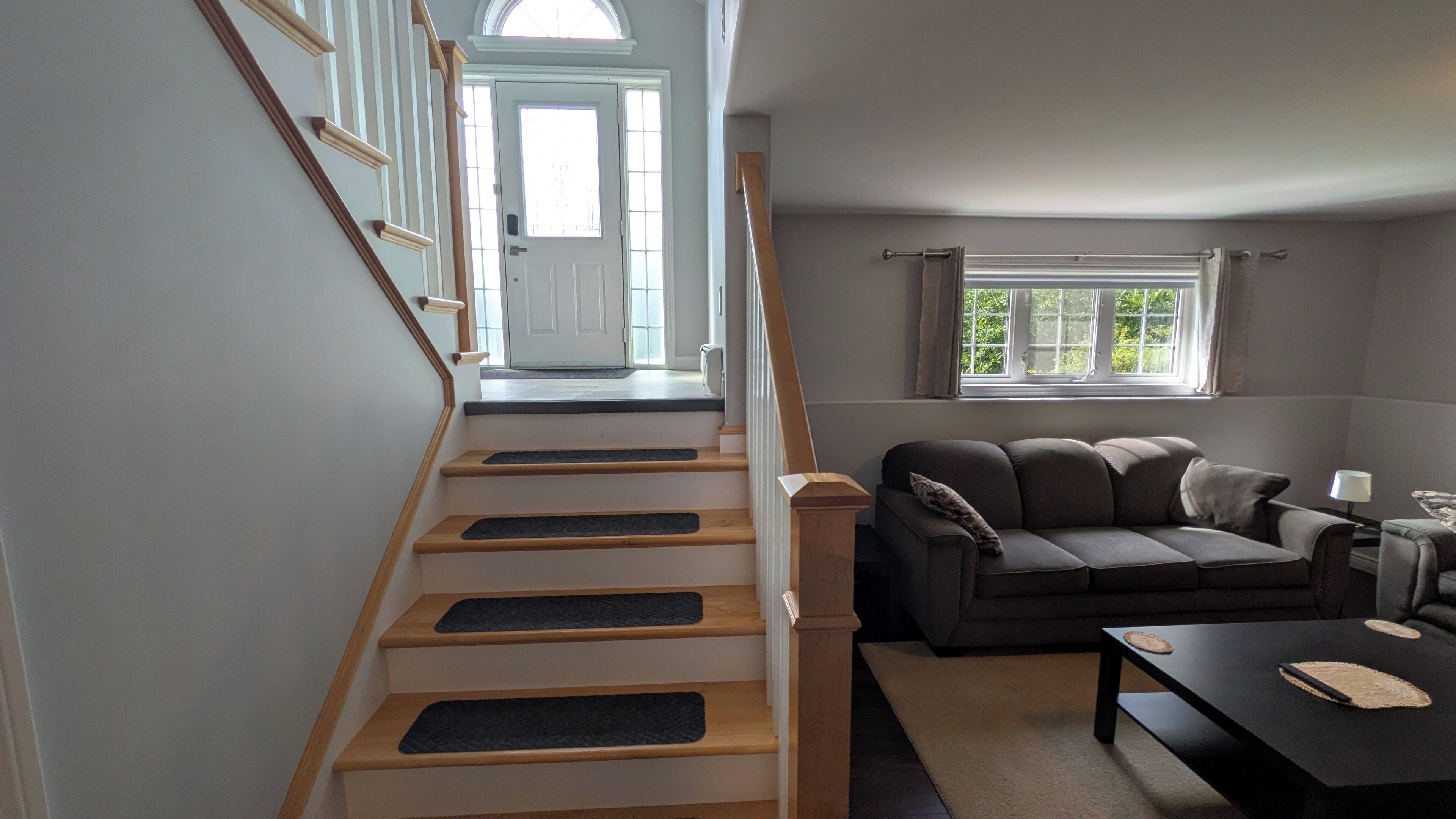 A staircase with wooden steps and a landing area with a sofa and a coffee table.