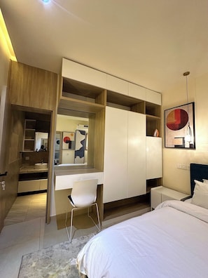 A modern bedroom with a built-in desk, a bed, and a wardrobe. - Purple Crown Hotel  (Ikeja)