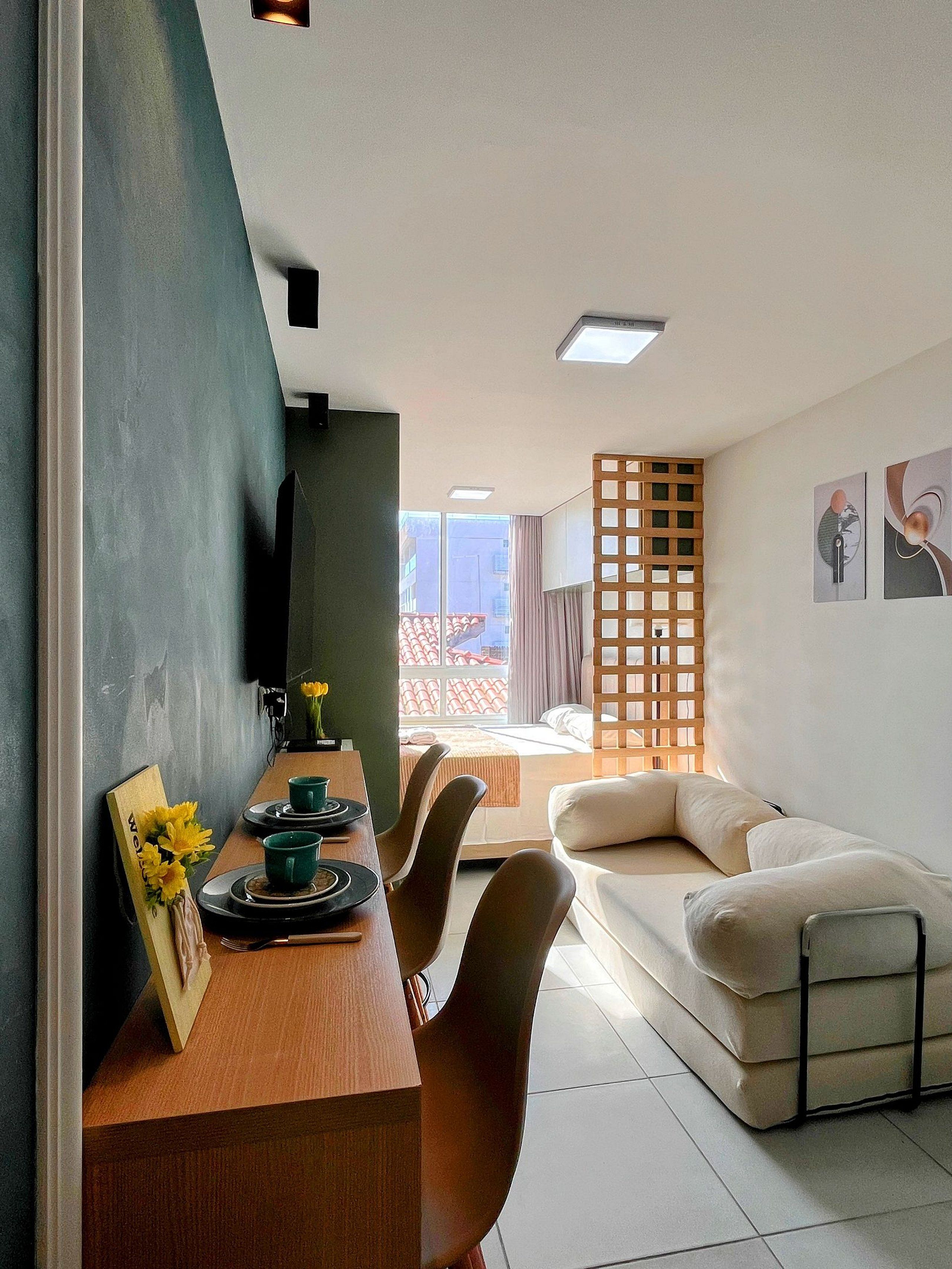 A modern living space with a dining area, a sofa, and artwork on the walls.