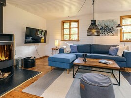 A cozy living room with a fireplace, a sofa, a coffee table, and a television.