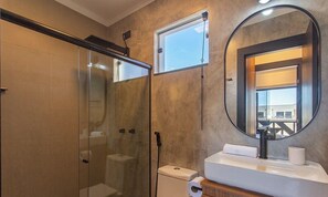 A bathroom with a glass-enclosed shower, a toilet, a sink with a mirror, and a window. - Apt. in Condo. w/ Pool 320m From Beach Dvb0014 (Porto Seguro)