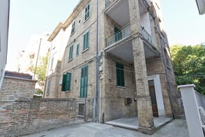 Un edificio de varios pisos con un balcón en el segundo nivel.