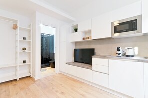 A modern kitchen with white cabinetry, a built-in microwave, and a coffee maker on the countertop. - Regina 33 - Studio Apartment, Sleeps 2 (Pescara)