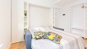 Ein Schlafzimmer mit einem Bett, einem Kleiderschrank und Regalen.