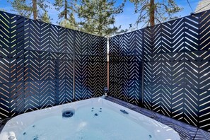 Un bain à remous avec un mur à motifs en chevrons derrière.