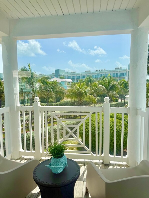 Un espacio al aire libre techado con vista a un conjunto de edificios y palmeras.