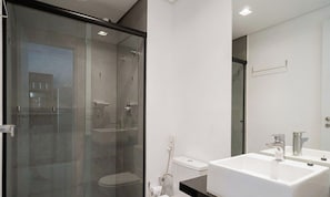 A modern bathroom with a glass shower enclosure, a white toilet, and a large sink with a mirror. - Comfort in Condo. w/ Pool in Tatuape Plt0115 (São Paulo)