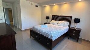 Ein Schlafzimmer mit einem großen Bett, zwei Nachttischen und einem Beistelltisch.