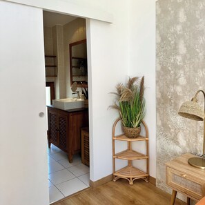 A bathroom with a wooden cabinet, a mirror, and a sink.