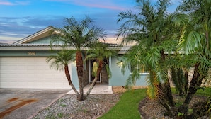 A residential property with a garage, palm trees, and a well-maintained lawn. - Resort that is kid friendly and close to beaches with 4 BR and Pool in Seminole (Seminole)
