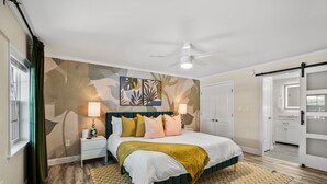 A bedroom with a bed, nightstands, a ceiling fan, a patterned rug, and a door leading to another room. - Resort that is kid friendly and close to beaches with 4 BR and Pool in Seminole (Seminole)