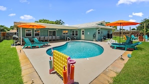 A backyard with a swimming pool, lounge chairs, and umbrellas. - Resort that is kid friendly and close to beaches with 4 BR and Pool in Seminole (Seminole)