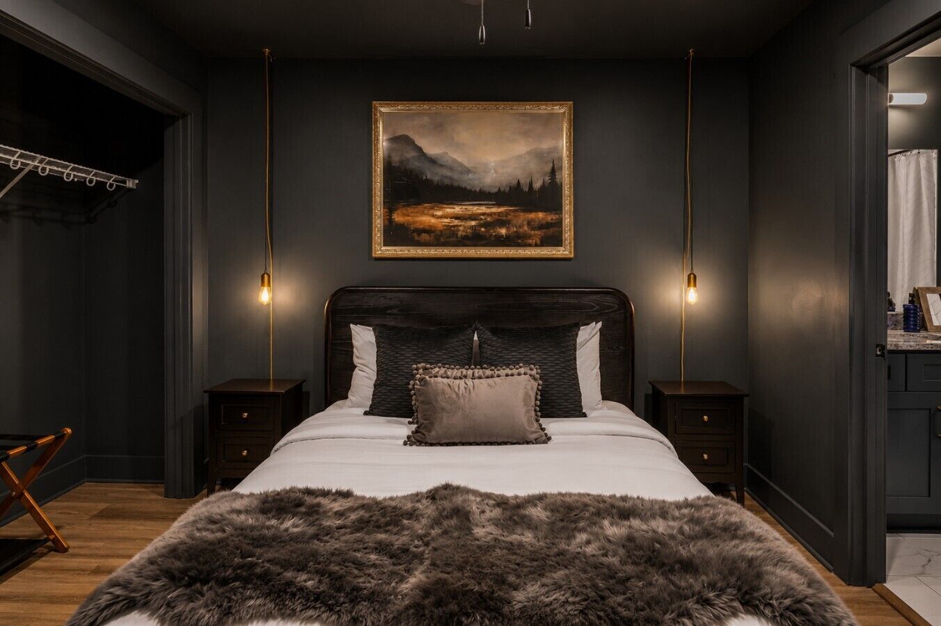 Een slaapkamer met een groot bed, twee nachtkastjes, een hangend schilderij en een bontwerp.