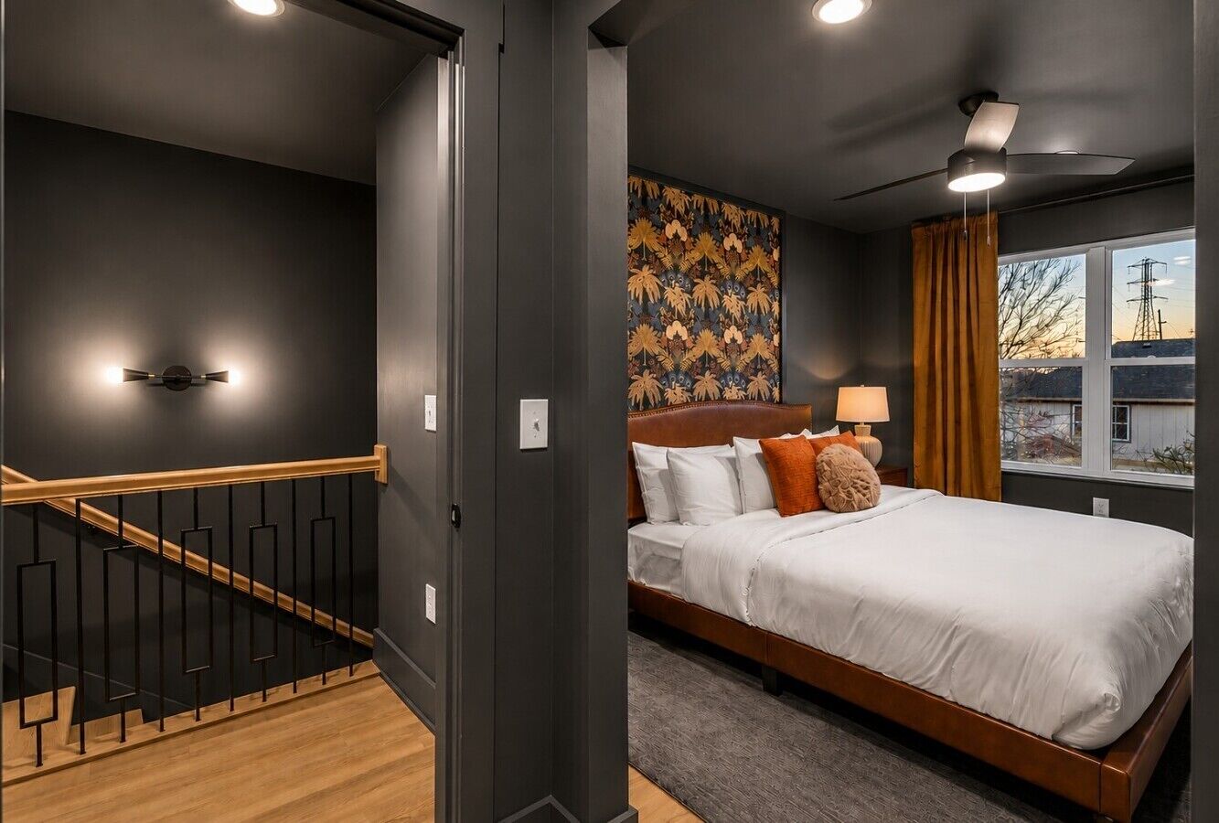 Rich leather and bold botanical patterns breaking up the dramatic matte walls.