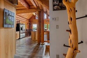 A wooden interior with a kitchen, dining area, and a view of the outdoors. - Mogul Hill Cabin - NEW Sundance Spa (Sandpoint)
