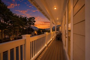 A wooden deck with railings, a covered porch, and a view of the sunset. - Drift-Away on 30a by Stay on 30a (Inlet Beach)