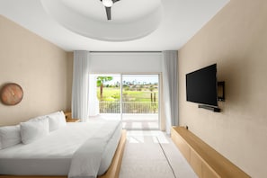 Une chambre à coucher avec un lit, un téléviseur fixé au mur et une vue sur un terrain de golf par la fenêtre.