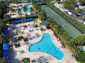 A resort with a large swimming pool, tennis courts, and shaded lounge areas. - Wonderful Apt! 14 floor. Parking included! (Sunny Isles Beach)