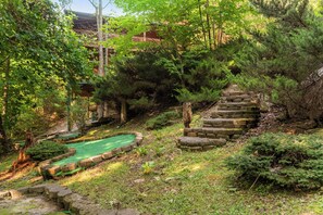 A traditional Japanese garden with a stone staircase, a small pond, and lush greenery. - Secluded Mountain Cabin with Hot Tub, Fire Pit, Games and Views (Sevierville)