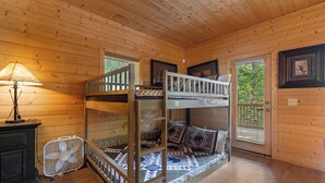 A bunk bed with a ladder, a desk with a lamp, and a fan in a wooden room with a window. - Secluded Mountain Cabin with Hot Tub, Fire Pit, Games and Views (Sevierville)