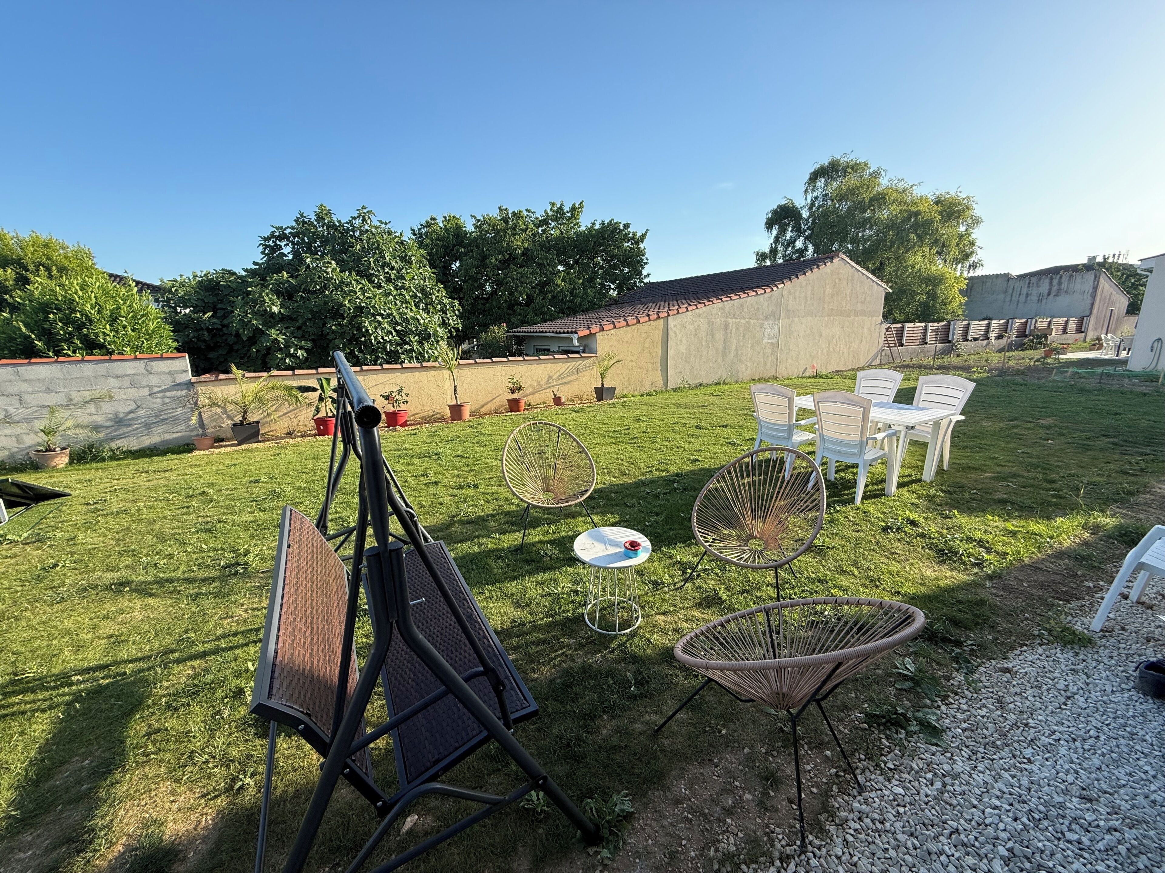 Un espacio al aire libre con patio, una mesa y sillas, un telescopio y macetas con plantas.
