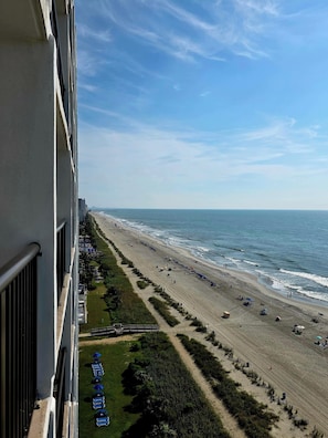 A beach with a clear view of the ocean and a promenade lined with umbrellas. - Club Regency (Myrtle Beach)