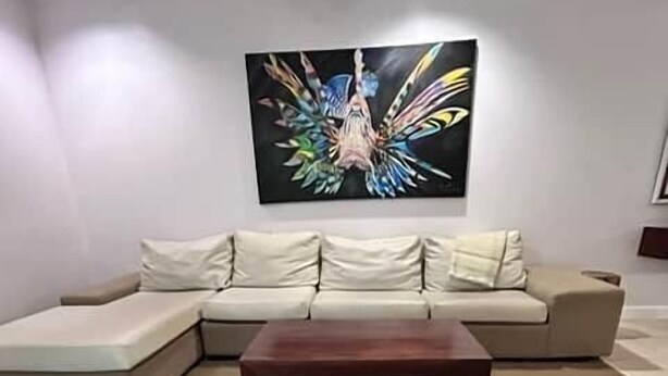Un saló amb un sofà modular, una taula de centre de fusta i un quadre abstracte gran a la paret.