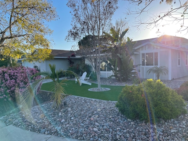 A residential property with a well-maintained lawn, a patio area with outdoor furniture, and a variety of plants and trees. - Wonderful 4-bedroom house with AC in sunny San Diego (San Diego)