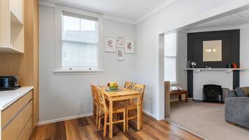 A compact living space with a dining area, kitchenette, and a fireplace.