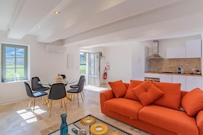 Ein modernes Wohnzimmer mit einer Couch und einem Essbereich mit Stühlen und einem Tisch.