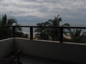 A balcony with a view of the beach and palm trees. - Mother's Place Nimala - Standard Double Room with Garden View (Hikkaduwa)