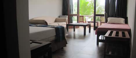 A room with two beds, a table, and a bench.