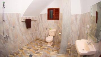 Un baño con ducha, inodoro y lavamanos.
