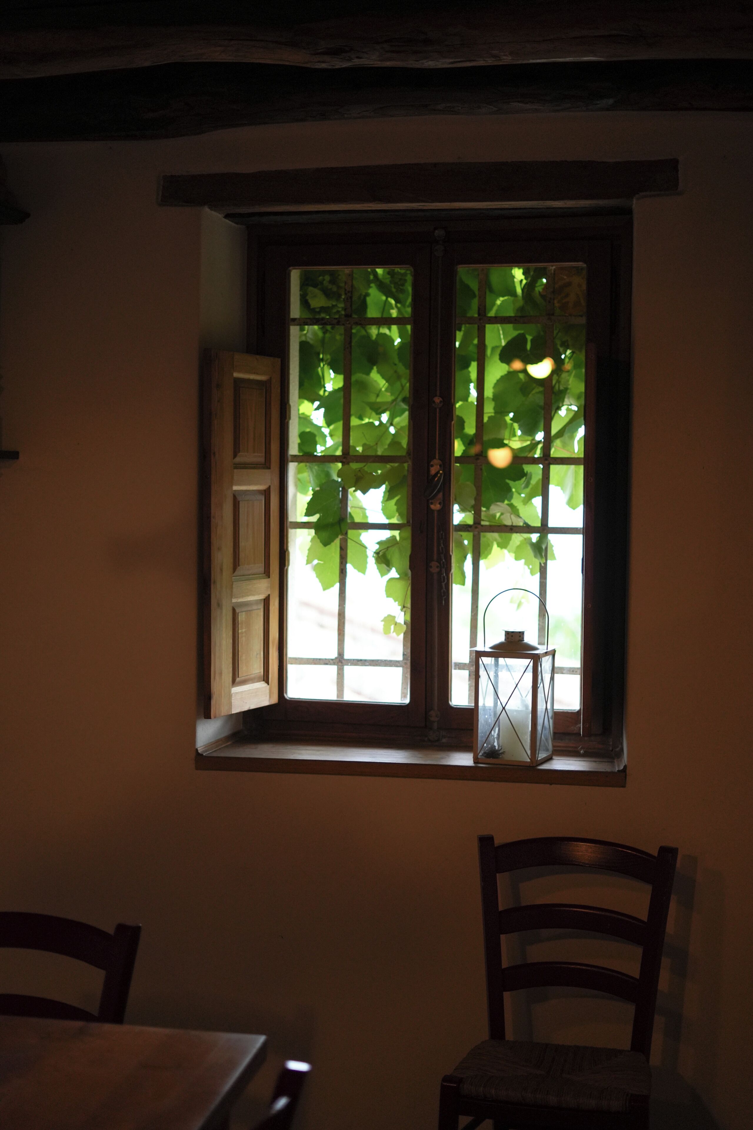 A room with a window, a chair, and a table.