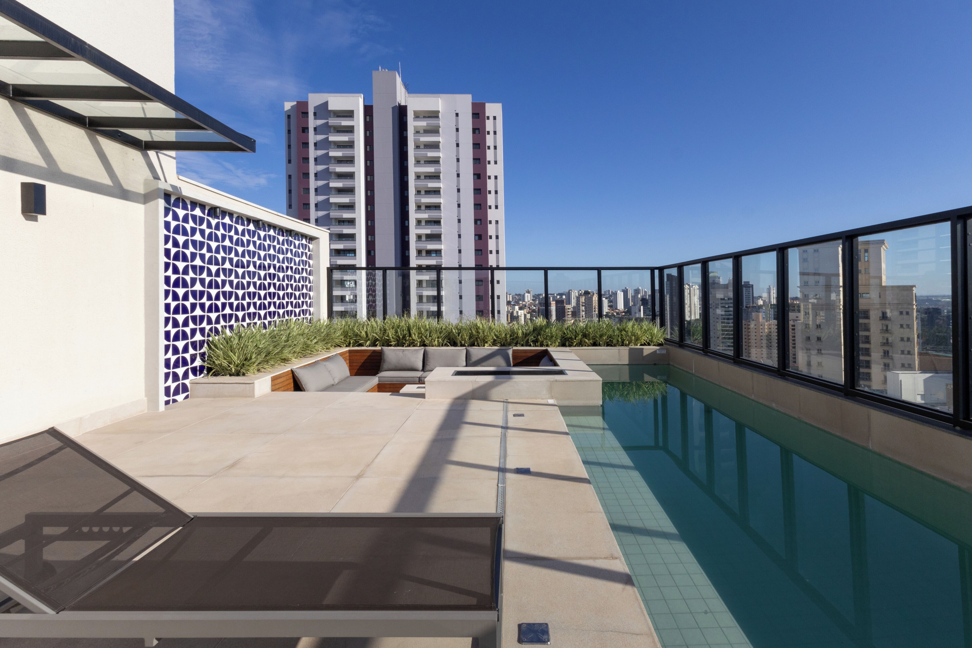 Une piscine située sur le toit, offrant une vue sur le paysage urbain et un grand bâtiment en arrière-plan.