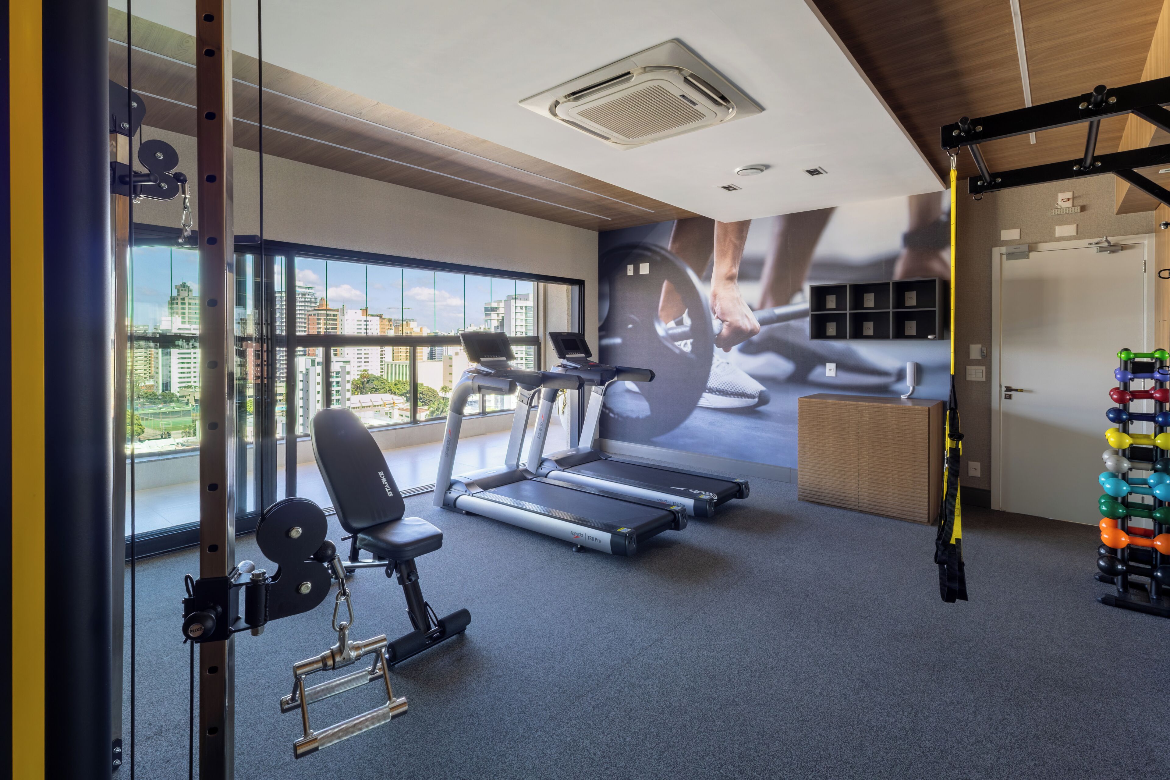 A gym with treadmills, a bench, and weightlifting equipment.