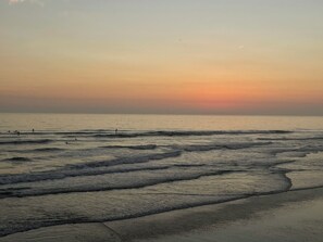Una platja amb onades i un capvespre.