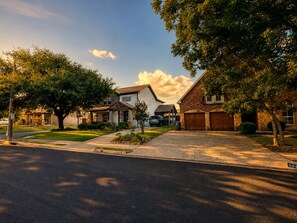 A residential street with houses, a driveway, and a clear sky. - 5BR and 3.5 BA in Lower Greenville Home with Game Room Sleeps 14 (Dallas)