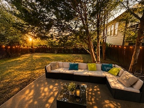 A sectional sofa with multiple cushions, a glass-top coffee table, and a potted plant. - 5BR and 3.5 BA in Lower Greenville Home with Game Room Sleeps 14 (Dallas)