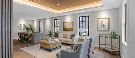 A modern living room with a wooden ceiling, a sofa, a coffee table, and a dining area with chairs and a table.
