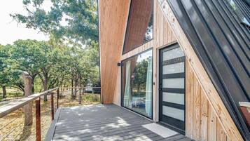 Un bâtiment moderne en bois, doté d’une porte en verre portant l’inscription « POST OAK » et d’une terrasse en bois.
