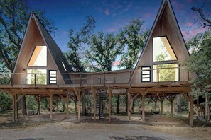 Eine Holzhütte mit zwei Satteldächern und großen Fenstern.
