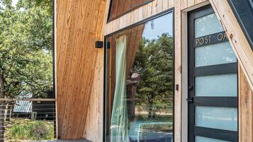 Un bâtiment moderne en bois, doté d’un toit en pente, de grandes fenêtres en verre et d’une terrasse.