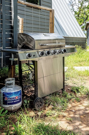 A Char-Broil gas grill with four burners, a propane tank, and a chimney. - A-Frame Ranch: Llano Cabin with Cowboy Pool (Fredericksburg)