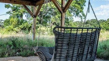 A wooden pergola with a hanging swing chair.