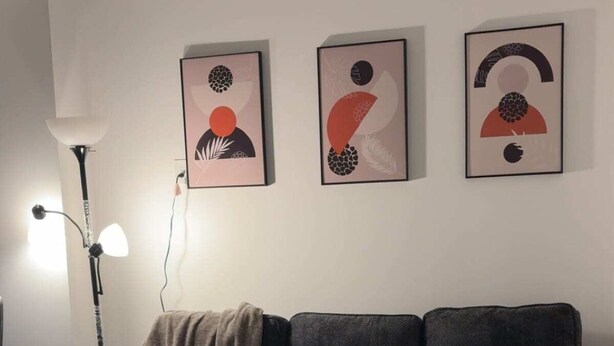 A modern living room with a sectional sofa, a glass coffee table, and abstract wall art. - One-Bedroom Executive Stay | Central & Convenient (Edmonton)