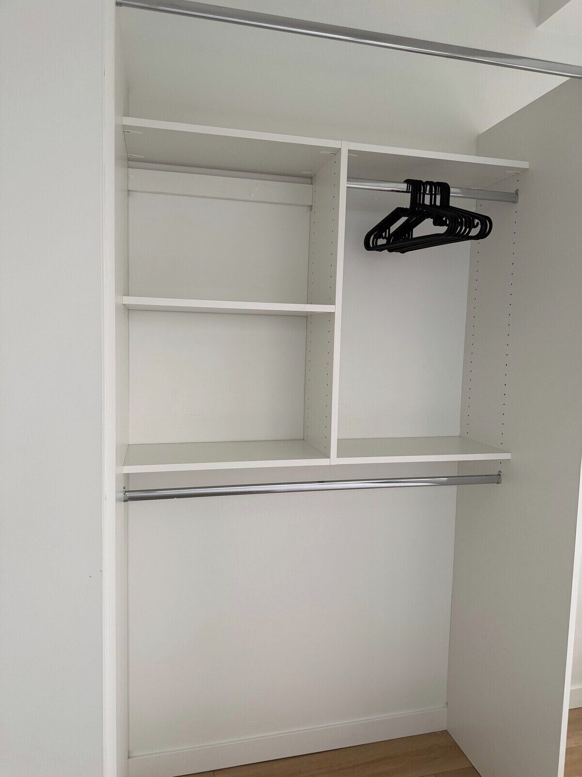 A white closet with multiple shelves and a hanging rod.