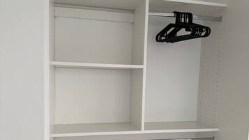 A white closet with multiple shelves and a hanging rod.