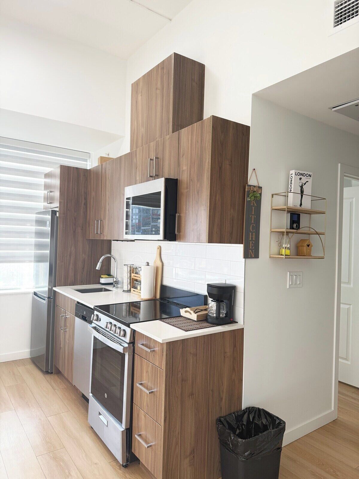 A modern kitchen with built-in appliances, a microwave, and a coffee maker.