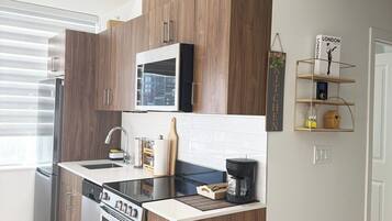 A modern kitchen with built-in appliances, a microwave, and a coffee maker.